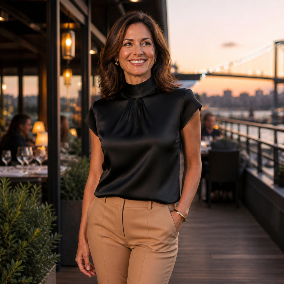 Woman in her forties wearing a black pleated satin blouse at an evening terrace — view 8