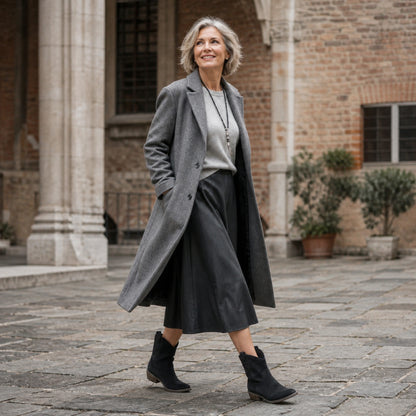 Mature woman wearing black Western ankle boots in a historic courtyard — view 10
