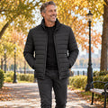 Jacket focused front view of the full Black Daniel Stand Collar Padded Winter Coat worn by a happy adult model in UK autumn