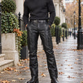 leather trousers — Front view of the full Black trousers worn by an adult model in a cool UK autumn street setting