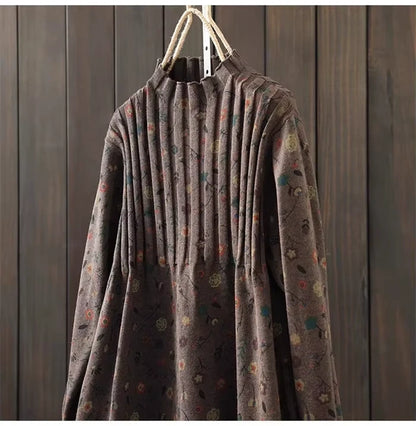 Brown knit midi jumper dress with pleated design and subtle floral pattern, hanging on a wooden background — view — view 32