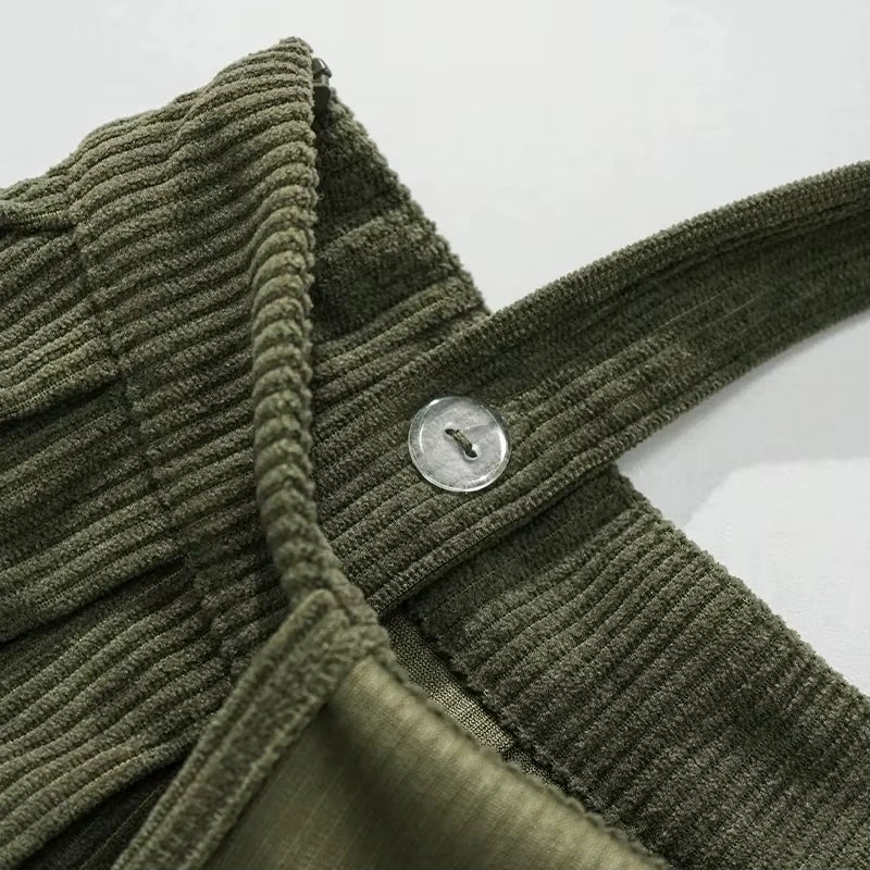 Close up of green corduroy fabric with button detail on a women's midi jumper dress — view 5 — view 10