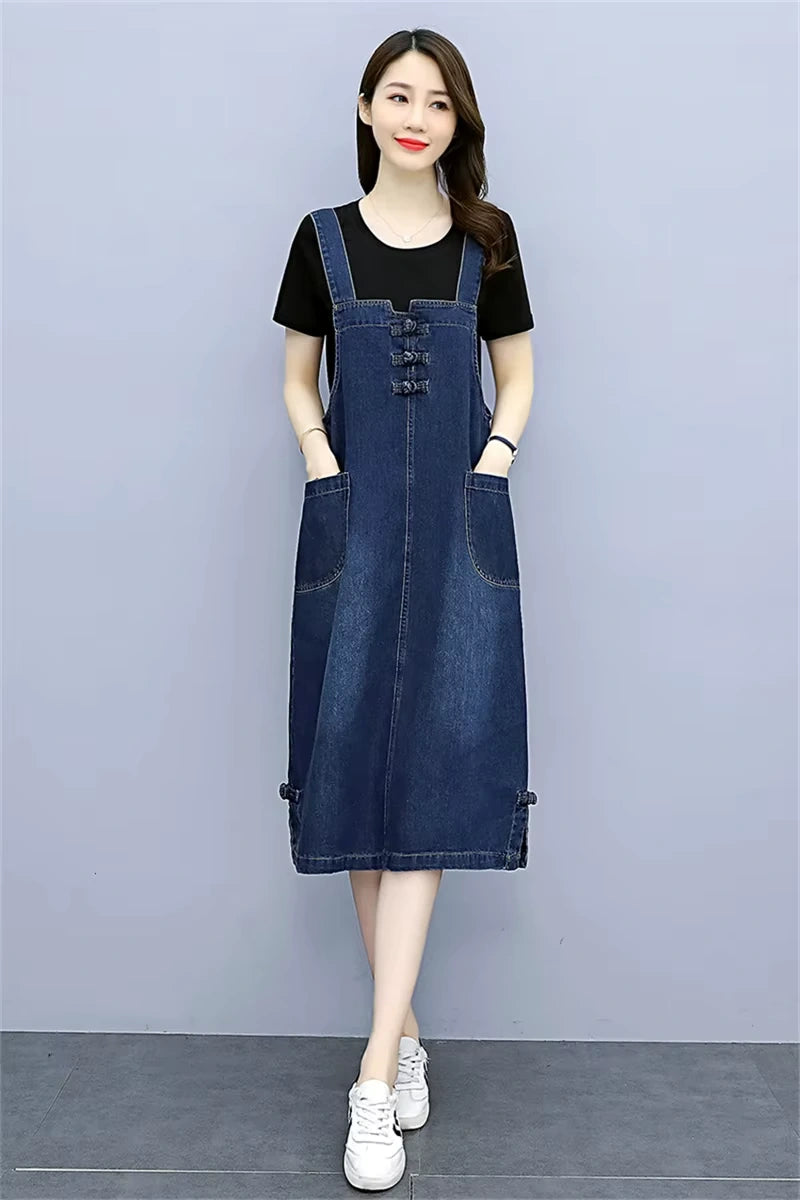 Women's loose fit denim knee length midi jumper dress with pockets, styled over a black top — view 14 — view 15
