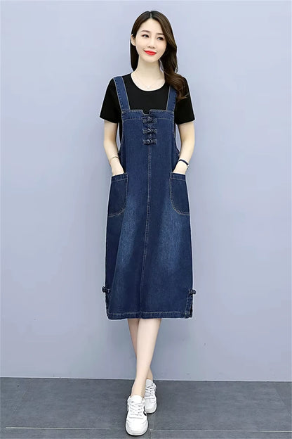 Women's loose fit denim knee length midi jumper dress with pockets, styled over a black top — view 14 — view 15