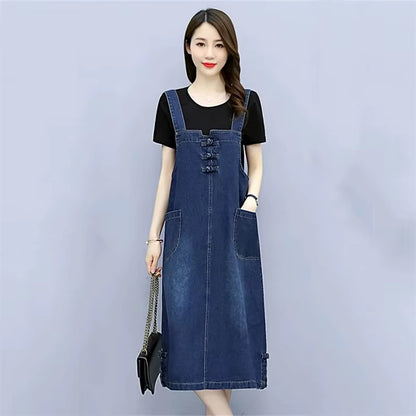 Women's loose fit denim knee length midi jumper dress with pockets, styled over a black top — view 2