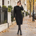 Women's Rib Knit Half High Collar Knee Length Midi Jumper Dress in Black, worn by a happy model UK autumn setting