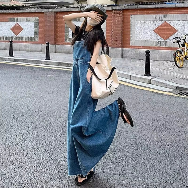 Woman wearing a denim midi jumper dress with zip detail, standing outdoors — view 6 — view 7