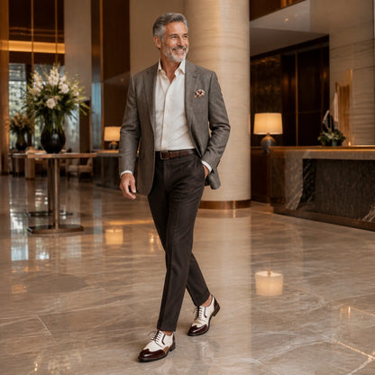 Mature man wearing cream and burgundy Oxford shoes in a hotel — view 7