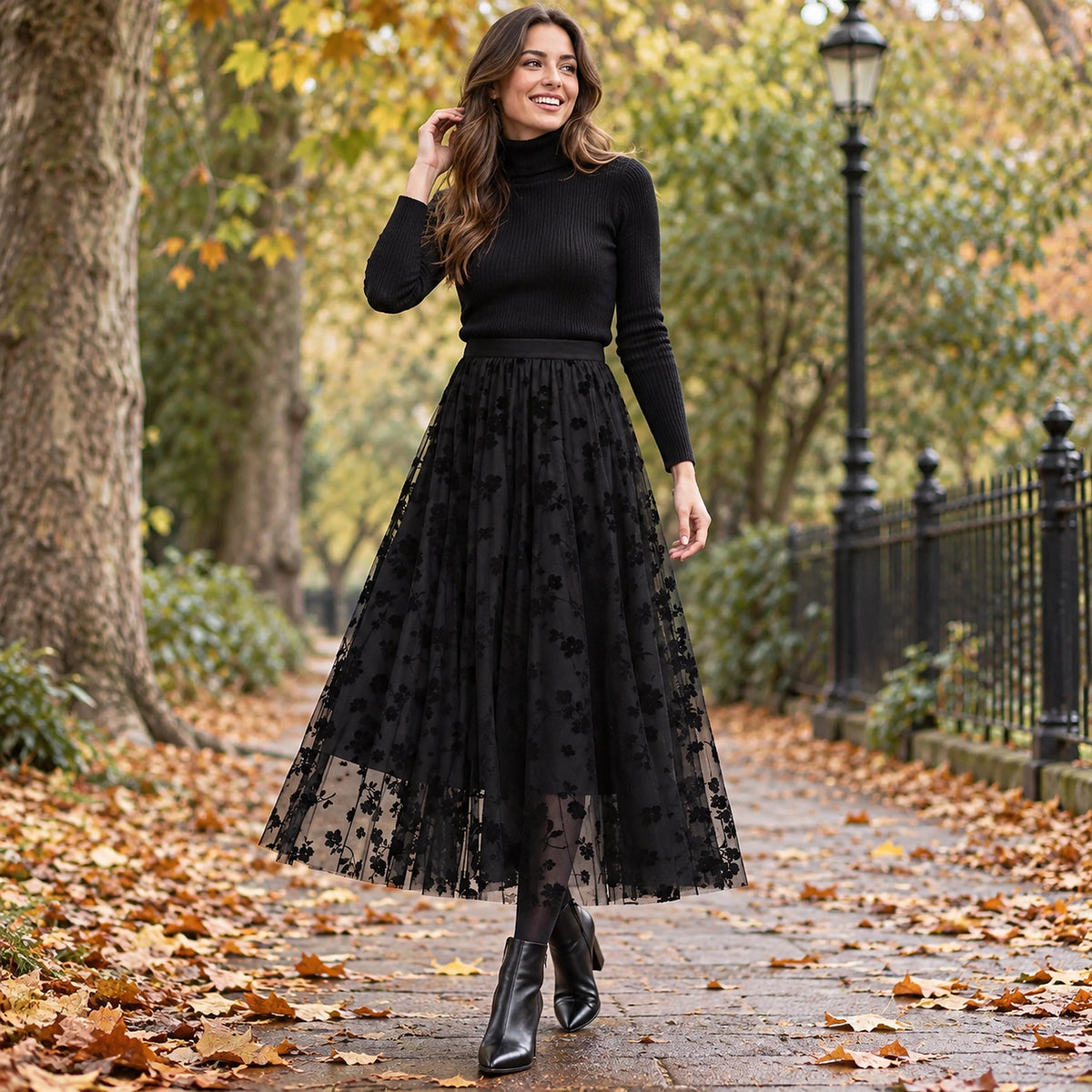 Happy adult model wearing the full Black Charlotte Floral High Waist A Line Mesh Pleated Skirt in cool UK autumn — view 5