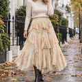 pleated skirt — Front view of the full Beige skirt worn by an adult model in a cool UK autumn street setting