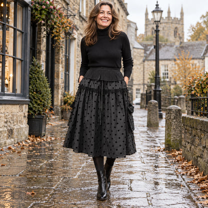 Happy adult model wearing the full Black Ruffle Lily Polka Dot A Line Mid Calf with Pockets Pleated Skirt in cool UK — view 4