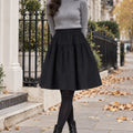 pleated skirt — Front view of the full Black skirt worn by an adult model in a cool UK autumn street setting