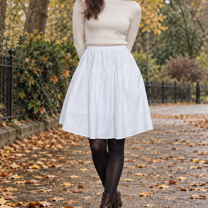 pleated skirt — Front view of the full White skirt worn by an adult model in a cool UK autumn street setting — view 3