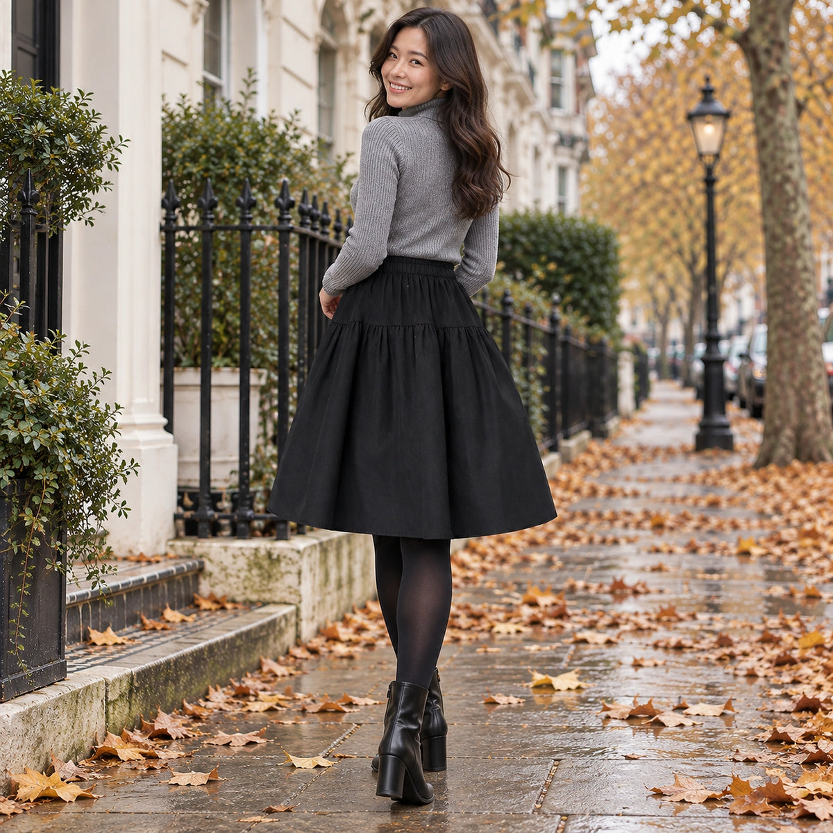 pleated skirt — Back full length view of the Black garment worn by a happy adult model in cool UK autumn setting — view 8