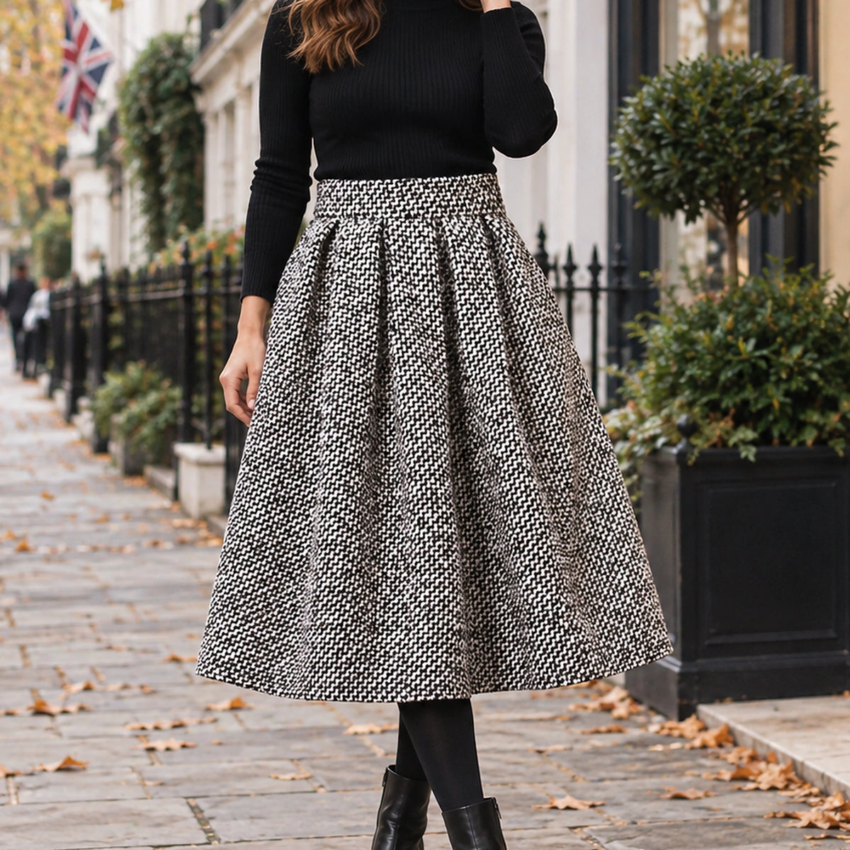 pleated skirt — Front view of the full Black White Tweed skirt worn by an adult model in a cool UK autumn street setting