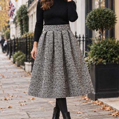 pleated skirt — Front view of the full Black White Tweed skirt worn by an adult model in a cool UK autumn street setting