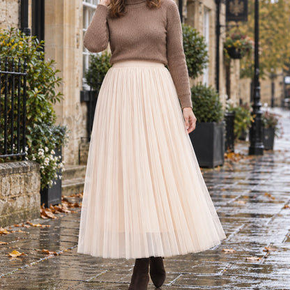 pleated skirt — Front view of the full Apricot 98 cm skirt worn by an adult model in a cool UK autumn street — view 12
