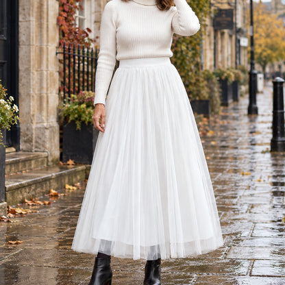 pleated skirt — Front view of the full White 98 cm skirt worn by an adult model in a cool UK autumn street setting — view 24