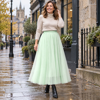 Happy adult model wearing the full Green Violet High Waisted A Line Tulle Pleated Skirt in cool UK autumn setting — view 36