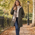 puffer jacket — Jacket focused front view of the full Olive Green Lily Hooded Ribbed Cuff Longline Puffer worn by a happy