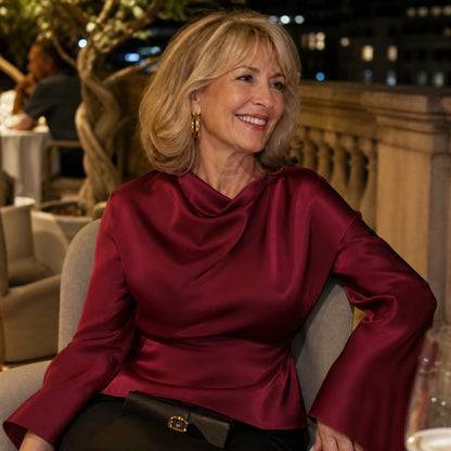 Woman in her fifties wearing a burgundy satin blouse at an evening terrace — view 10