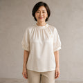 Champagne gathered satin blouse complete front view on a mature woman