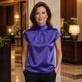 Violet high neck pleated satin blouse complete front view on a mature woman