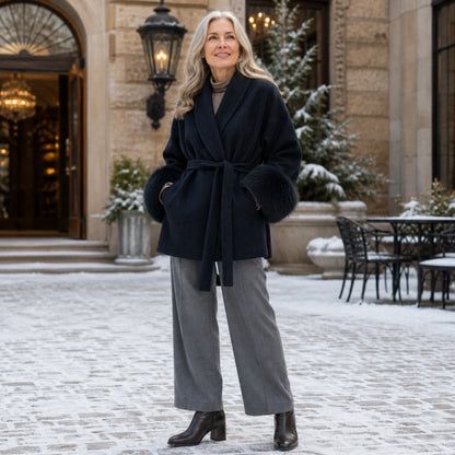 winter coat — Mature woman wearing midnight navy plush cuff wrap coat in a winter hotel courtyard — view 10