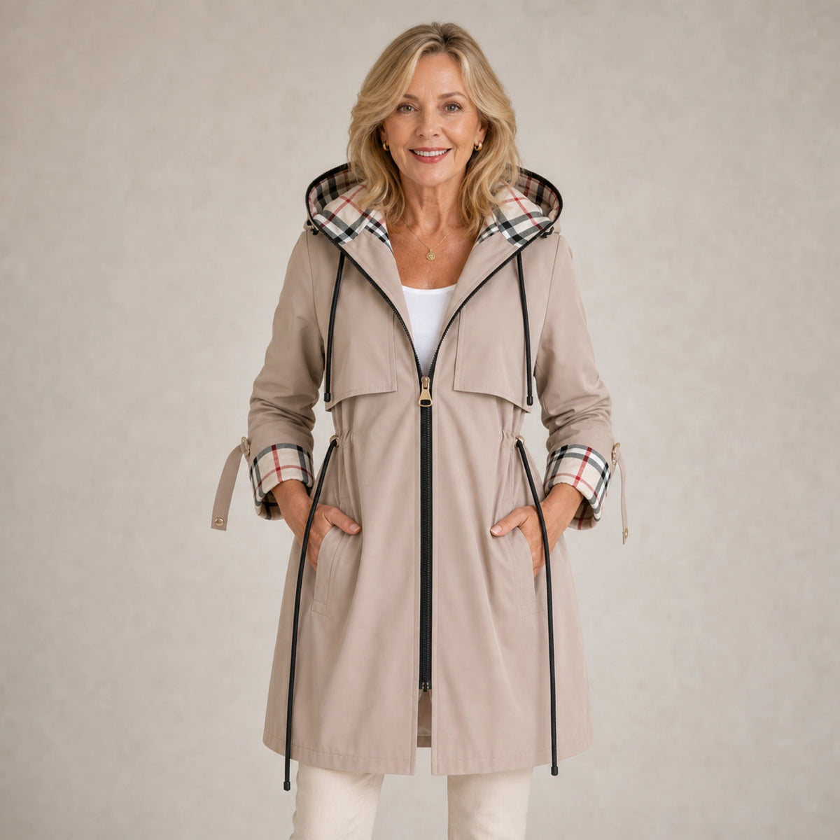 winter coat — Mature woman wearing light beige plaid lined adjustable hooded long coat front view — view 2